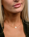 Close up of someone wearing a delicate The Finest Stack double layered cloud necklace.