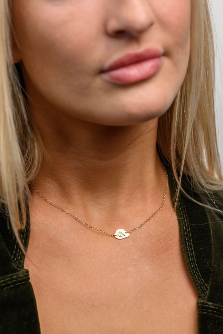 Close up of someone wearing a delicate The Finest Stack double layered cloud necklace.